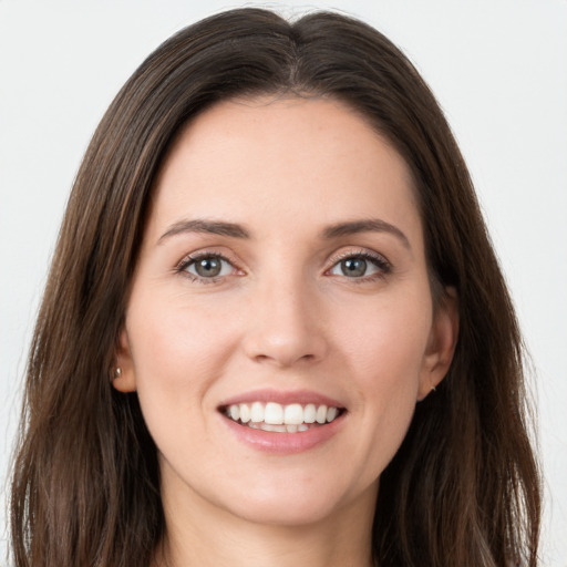 Joyful white young-adult female with long  brown hair and green eyes