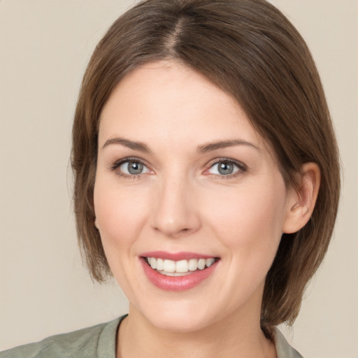 Joyful white young-adult female with medium  brown hair and grey eyes