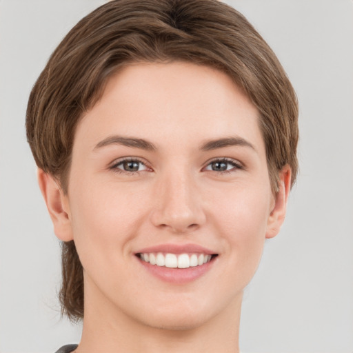 Joyful white young-adult female with short  brown hair and grey eyes