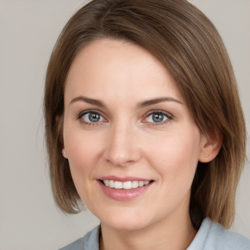 Joyful white young-adult female with medium  brown hair and grey eyes