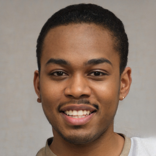 Joyful black young-adult male with short  black hair and brown eyes