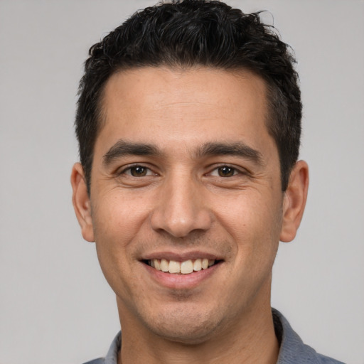 Joyful white young-adult male with short  black hair and brown eyes
