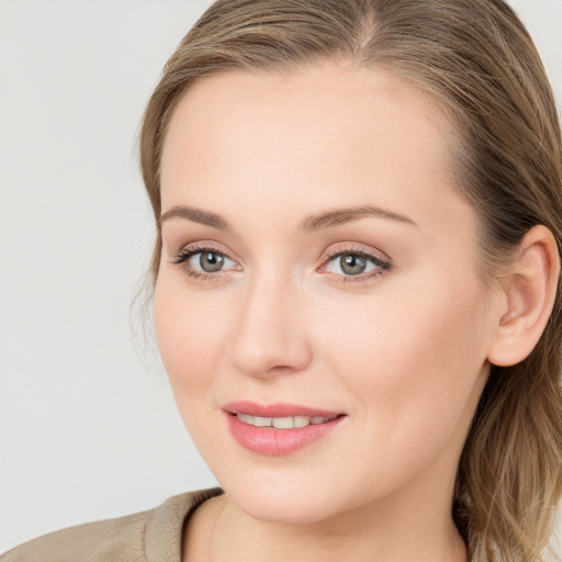 Joyful white young-adult female with long  brown hair and blue eyes