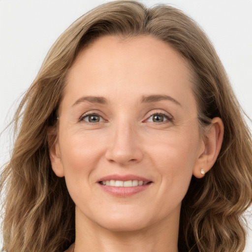 Joyful white adult female with long  brown hair and grey eyes