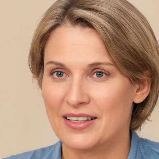 Joyful white adult female with medium  brown hair and brown eyes