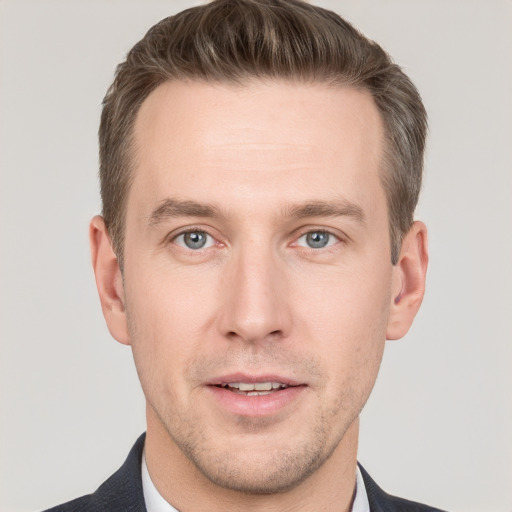 Joyful white young-adult male with short  brown hair and grey eyes