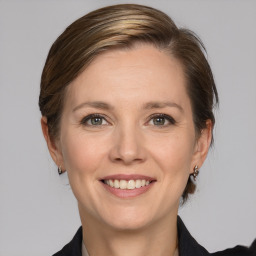 Joyful white adult female with medium  brown hair and grey eyes