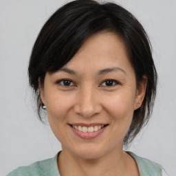 Joyful asian young-adult female with medium  brown hair and brown eyes