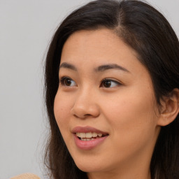 Joyful asian young-adult female with long  brown hair and brown eyes