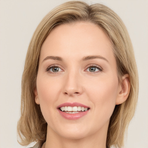 Joyful white young-adult female with long  brown hair and green eyes