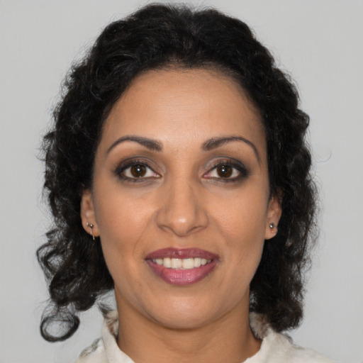 Joyful latino adult female with medium  brown hair and brown eyes