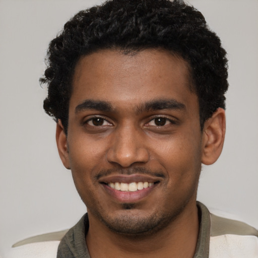 Joyful black young-adult male with short  black hair and brown eyes