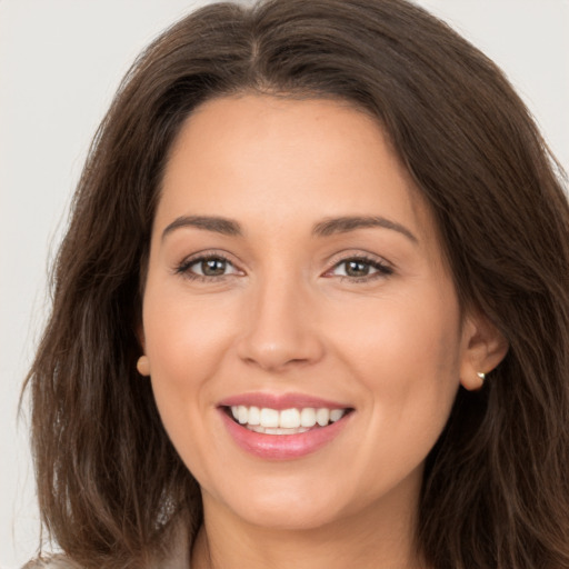 Joyful white young-adult female with long  brown hair and brown eyes