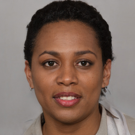 Joyful black young-adult female with short  black hair and brown eyes
