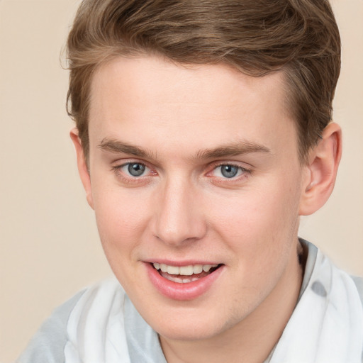 Joyful white young-adult male with short  brown hair and blue eyes