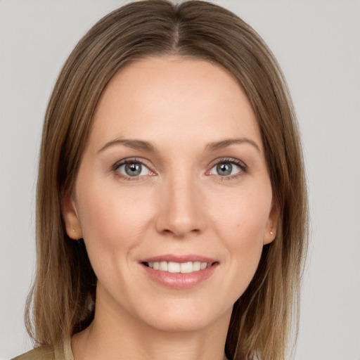 Joyful white young-adult female with medium  brown hair and grey eyes