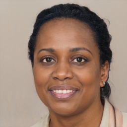 Joyful black young-adult female with long  black hair and brown eyes