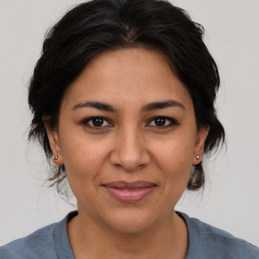 Joyful latino young-adult female with medium  brown hair and brown eyes
