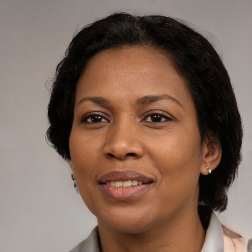 Joyful black adult female with medium  brown hair and brown eyes