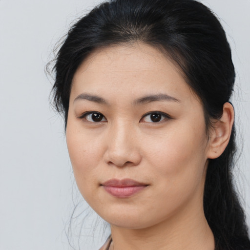 Joyful asian young-adult female with long  brown hair and brown eyes