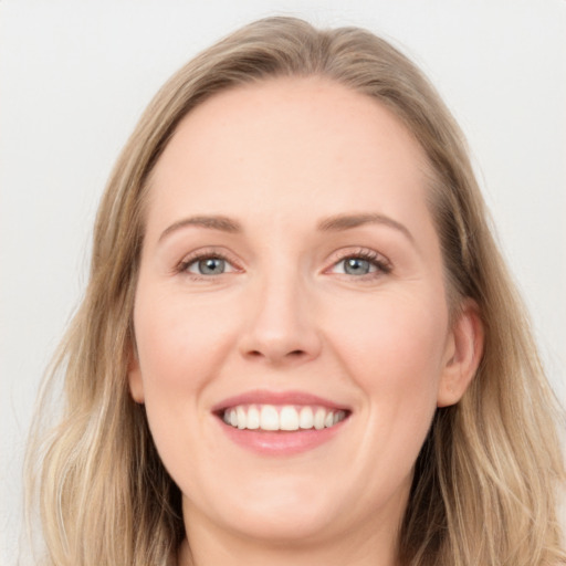 Joyful white young-adult female with long  brown hair and blue eyes