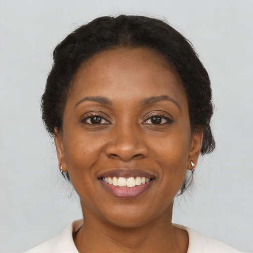Joyful black adult female with medium  brown hair and brown eyes