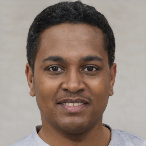Joyful black young-adult male with short  black hair and brown eyes