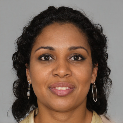 Joyful black young-adult female with long  brown hair and brown eyes