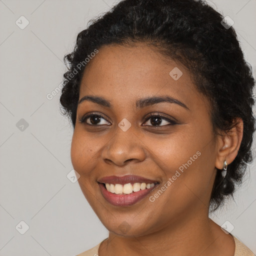 Joyful black young-adult female with short  black hair and brown eyes