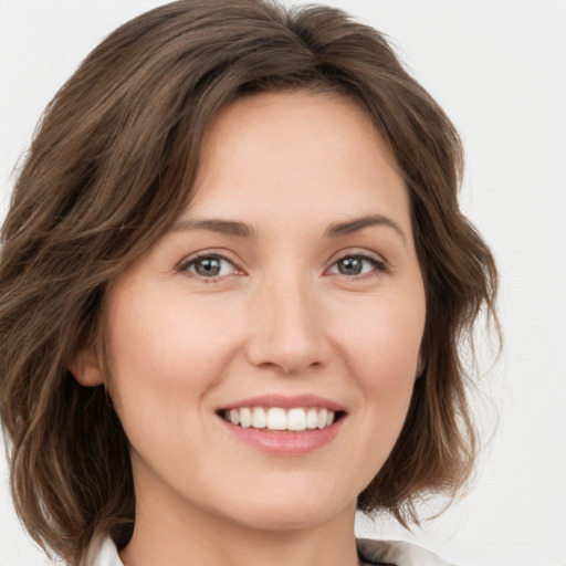 Joyful white young-adult female with medium  brown hair and green eyes