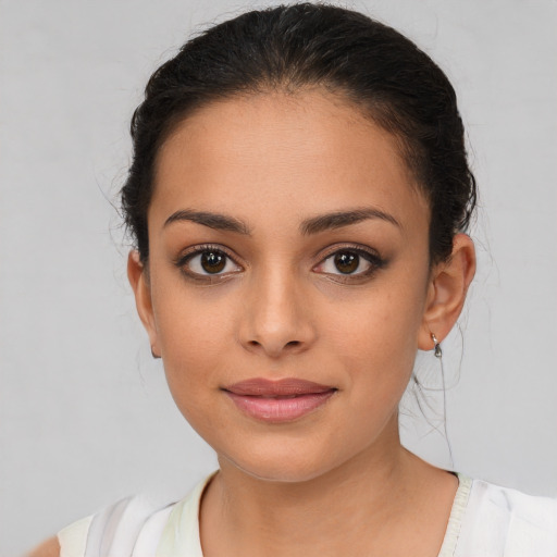 Joyful latino young-adult female with medium  brown hair and brown eyes