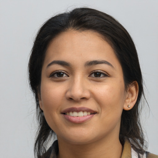 Joyful latino young-adult female with long  brown hair and brown eyes