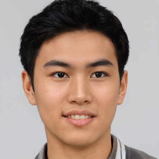 Joyful asian young-adult male with short  brown hair and brown eyes