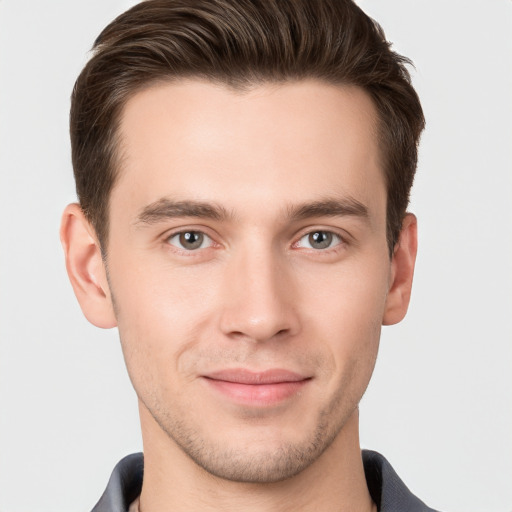 Joyful white young-adult male with short  brown hair and grey eyes