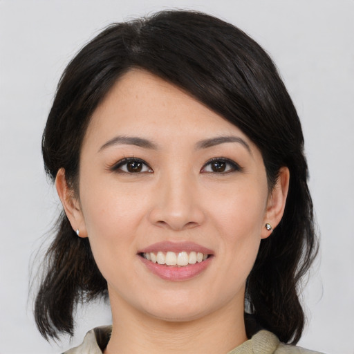 Joyful asian young-adult female with medium  black hair and brown eyes