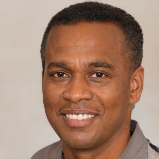 Joyful black adult male with short  brown hair and brown eyes