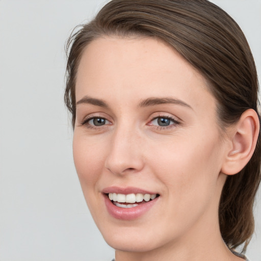 Joyful white young-adult female with medium  brown hair and grey eyes