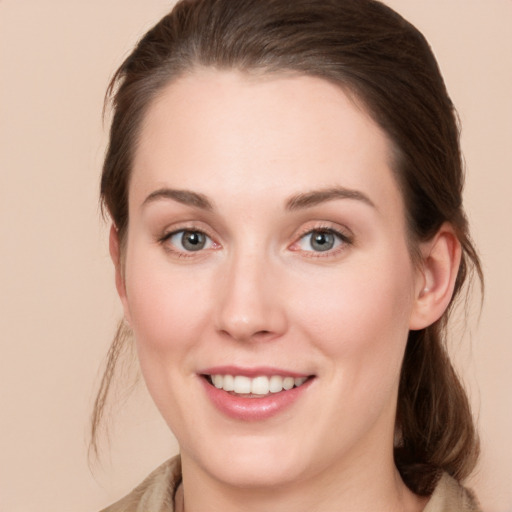 Joyful white young-adult female with medium  brown hair and grey eyes