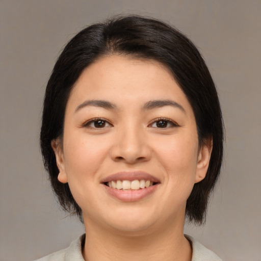Joyful asian young-adult female with medium  brown hair and brown eyes