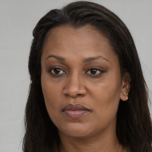 Joyful black adult female with long  brown hair and brown eyes