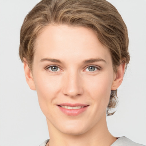 Joyful white young-adult female with short  brown hair and grey eyes