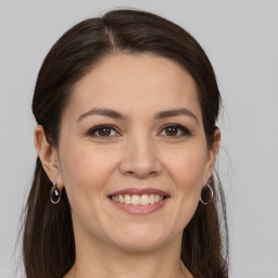 Joyful white young-adult female with long  brown hair and grey eyes