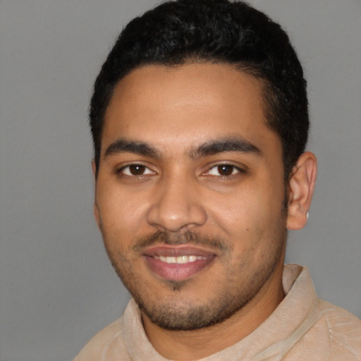 Joyful latino young-adult male with short  black hair and brown eyes