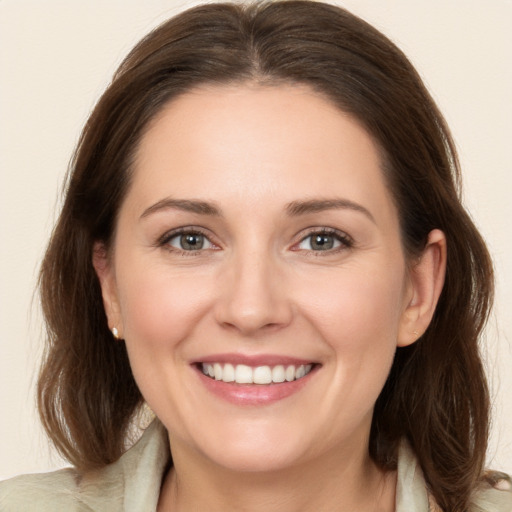 Joyful white young-adult female with medium  brown hair and grey eyes