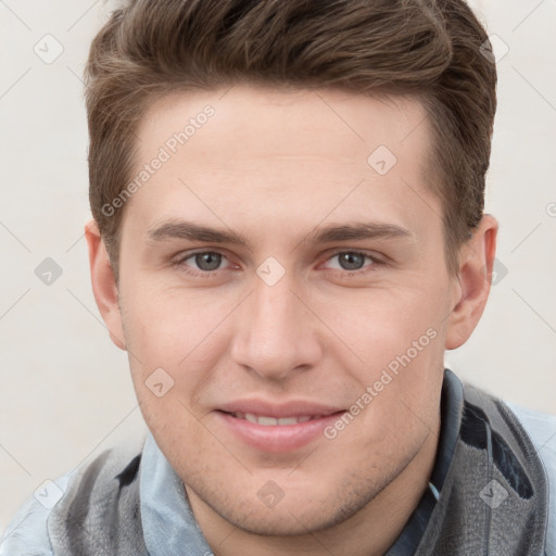 Joyful white young-adult male with short  brown hair and grey eyes