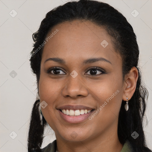 Joyful black young-adult female with long  black hair and brown eyes