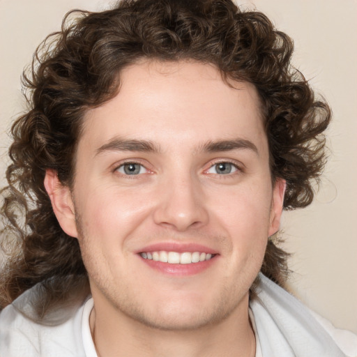 Joyful white young-adult male with medium  brown hair and blue eyes