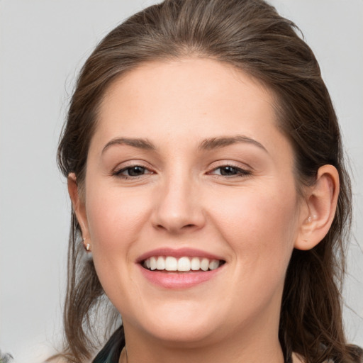 Joyful white young-adult female with medium  brown hair and grey eyes