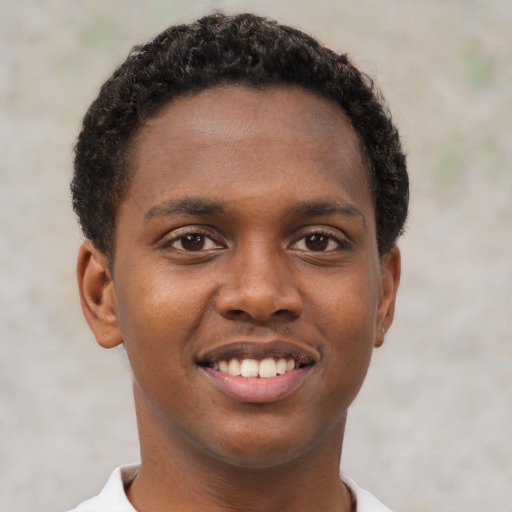 Joyful black young-adult male with short  brown hair and brown eyes