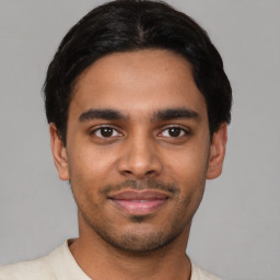 Joyful latino young-adult male with short  black hair and brown eyes